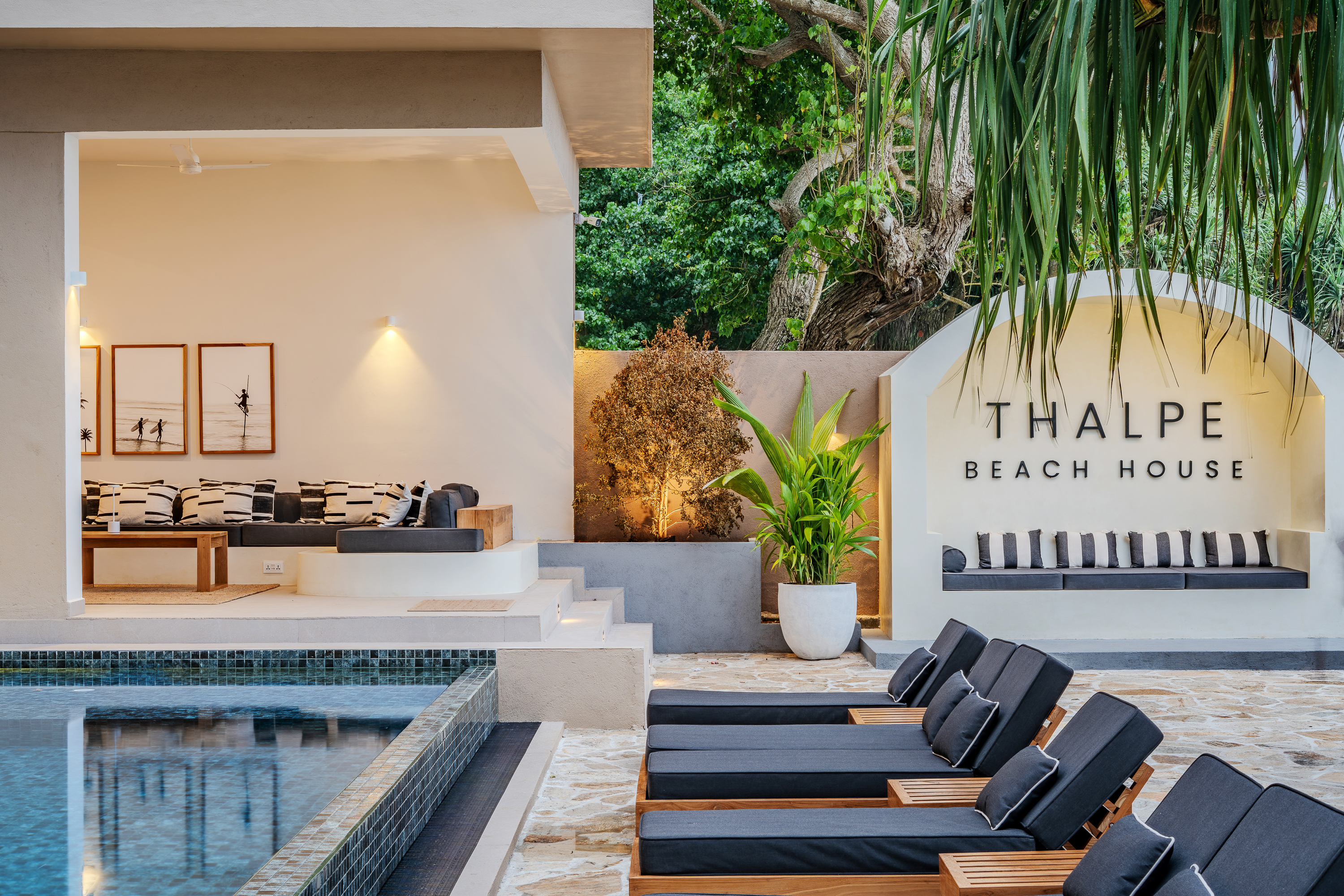 Thalpe Beach House - sign and pool lounge at evening