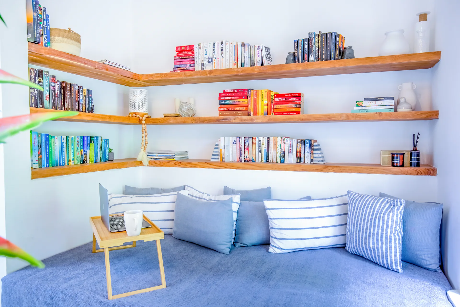 Reading nook with floor-to-ceiling bookshelves and blue linen cushions