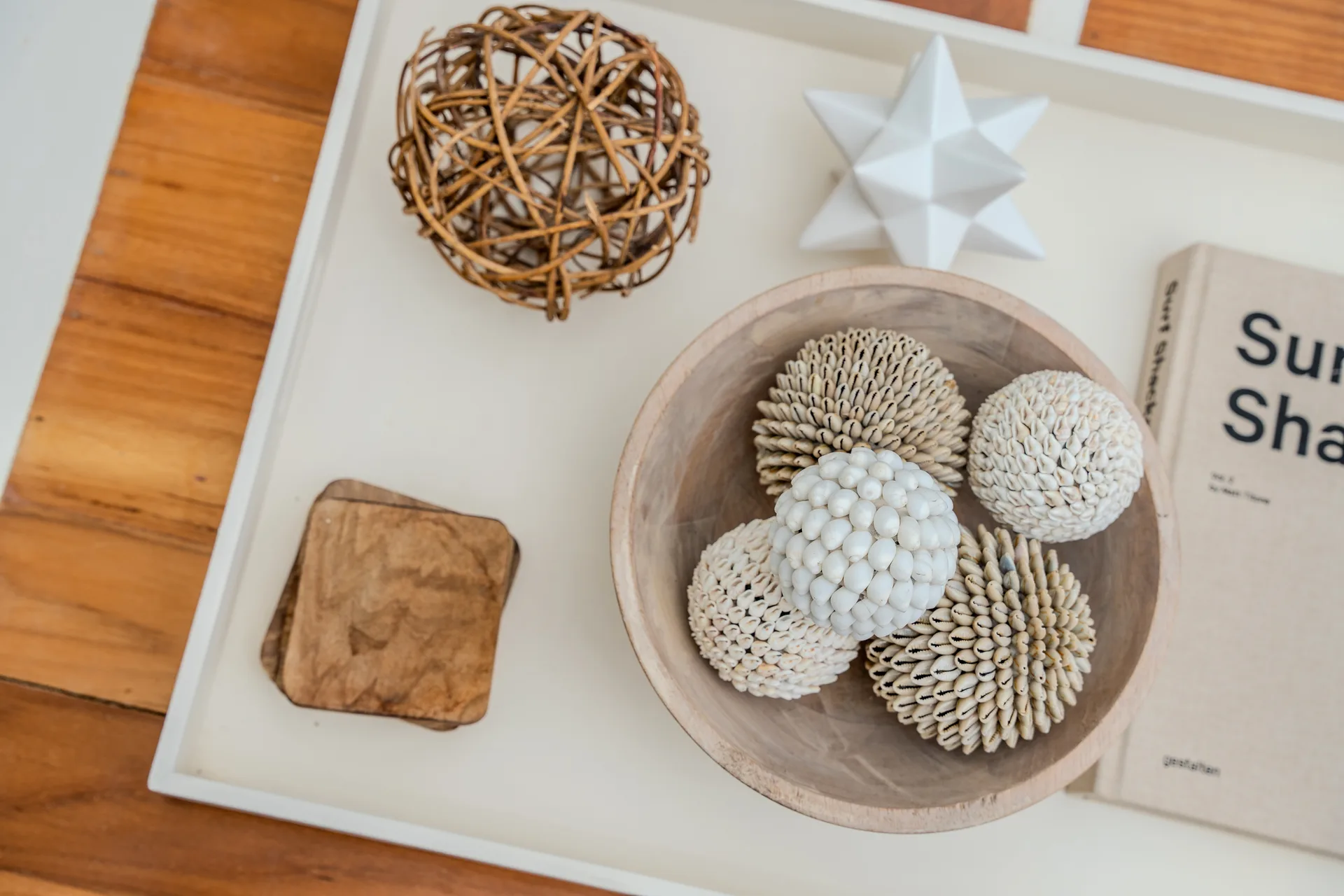 Decorative tray with shell bowls, ceramics and coffee table book