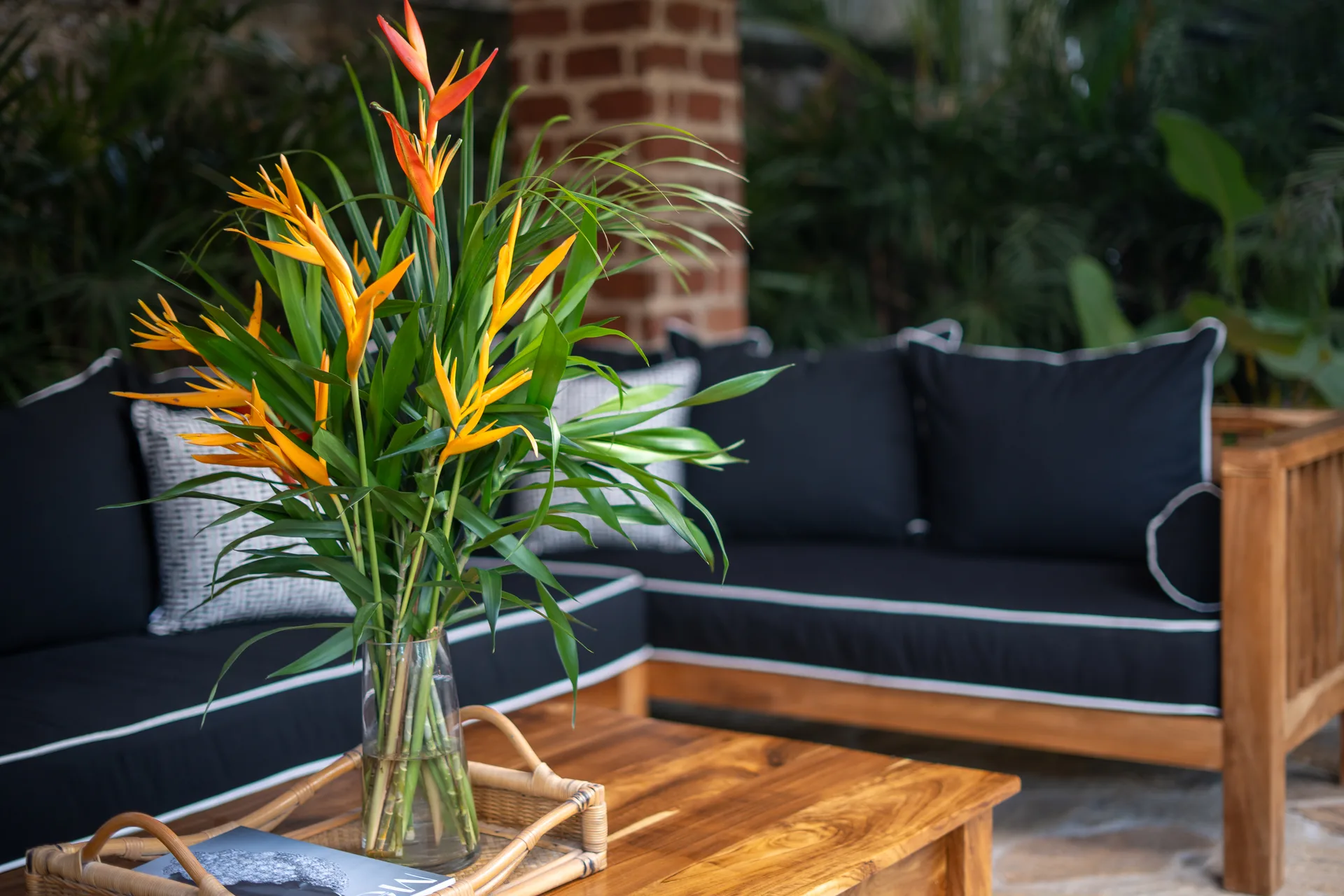 Outdoor lounge with heliconia flowers and teak coffee table