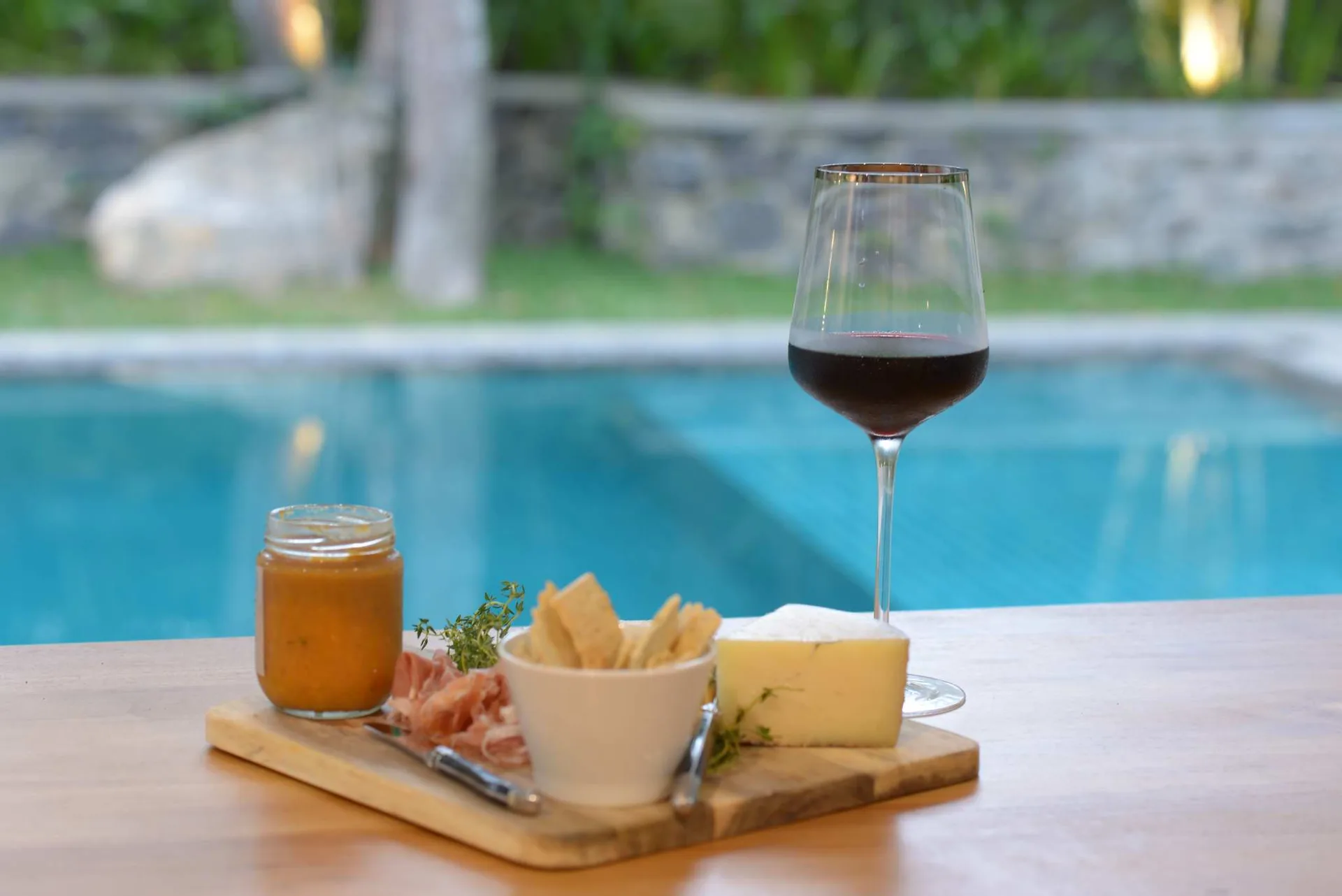 Sundowners by the pool - cheese board and wine at dusk